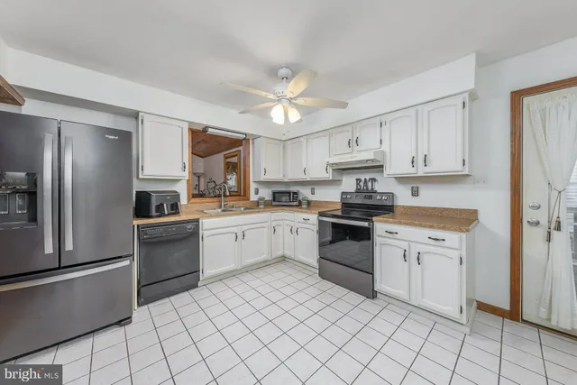 a kitchen with granite countertop appliances cabinets and a sink