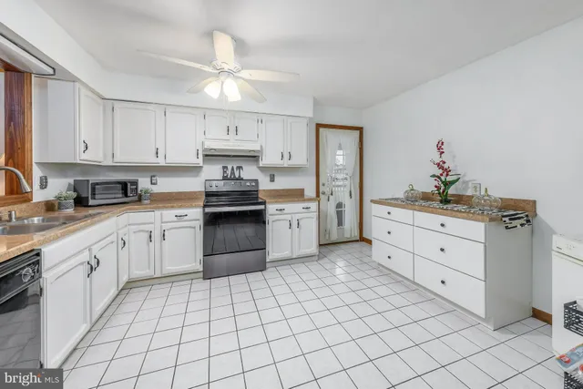 a kitchen with white cabinets appliances and a sink