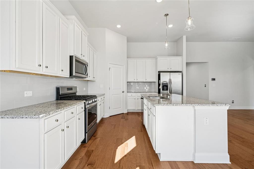 3431 High Shoals Buford, GA 30519 - Photo 14 of 51 a kitchen with stainless steel appliances kitchen island granite countertop a sink and a stove