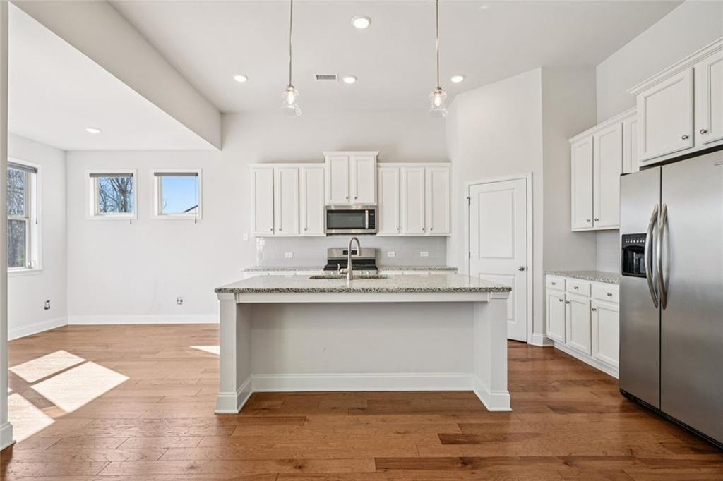 3431 High Shoals Buford, GA 30519 - Photo 7 of 51 a kitchen with stainless steel appliances granite countertop a sink stove and refrigerator