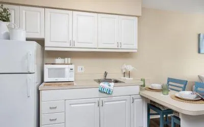 a kitchen with white cabinets and sink