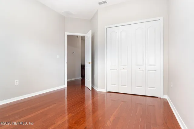 an empty room with wooden floor and closet