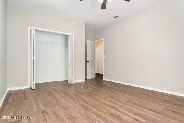 a view of an empty room with wooden floor