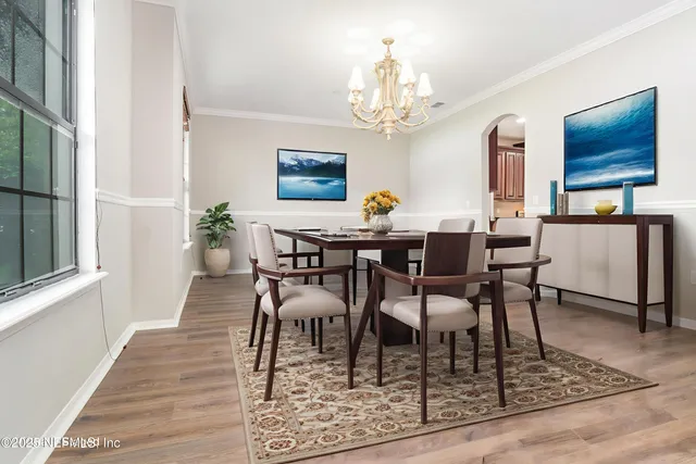 a view of a dining room with furniture a chandelier and wooden floor