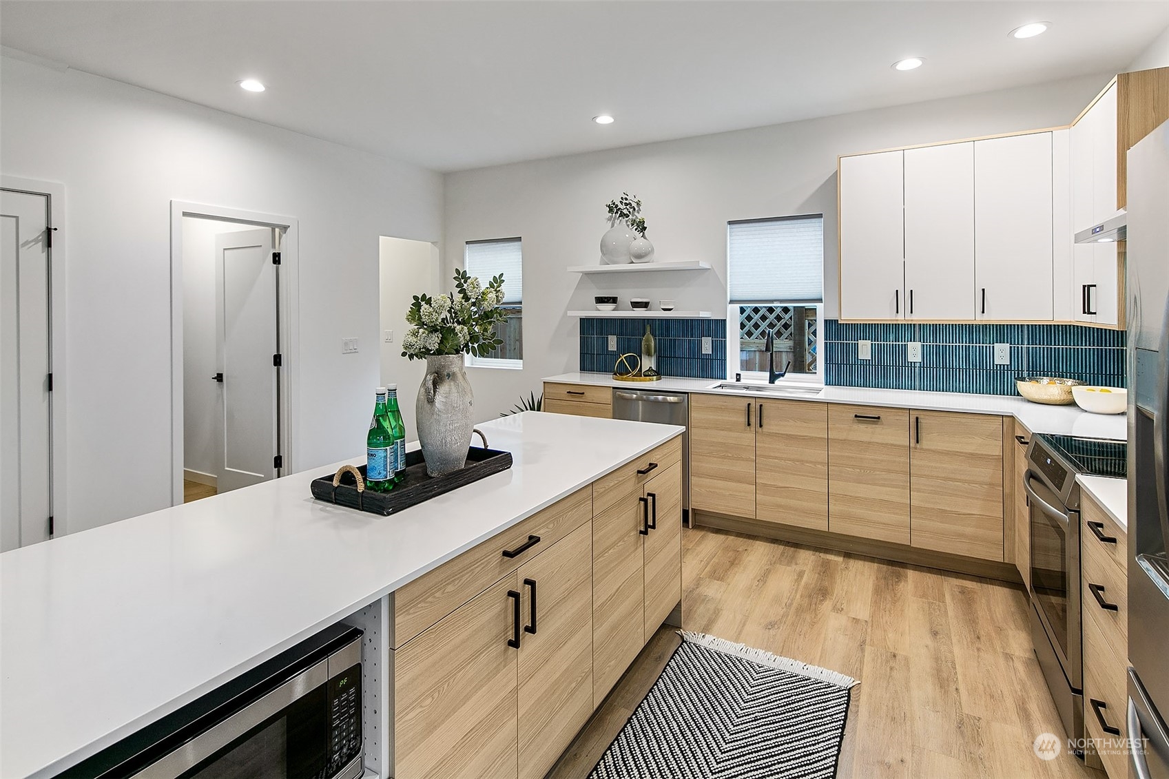 8855 29th Avenue Southwest Seattle, WA 98126 - Photo 9 of 20 a kitchen with stainless steel appliances sink cabinets and wooden floor