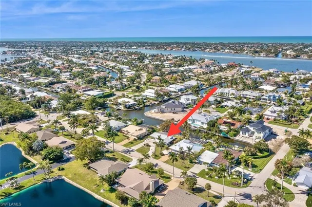 an aerial view of residential houses with outdoor space and trees