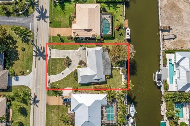 aerial view of a house with a yard and large trees