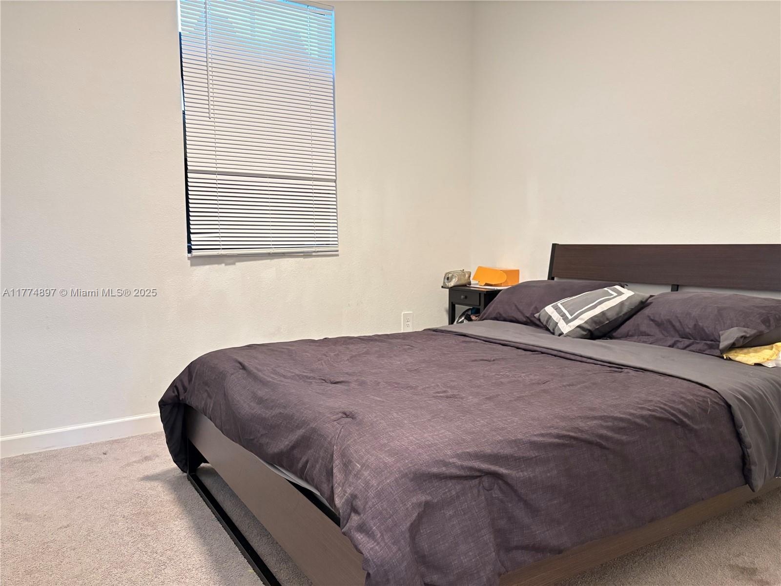 11772 Southwest 247th Terrace, Unit 11772 Homestead, FL 33032 - Photo 13 of 27 a bedroom with bed and window