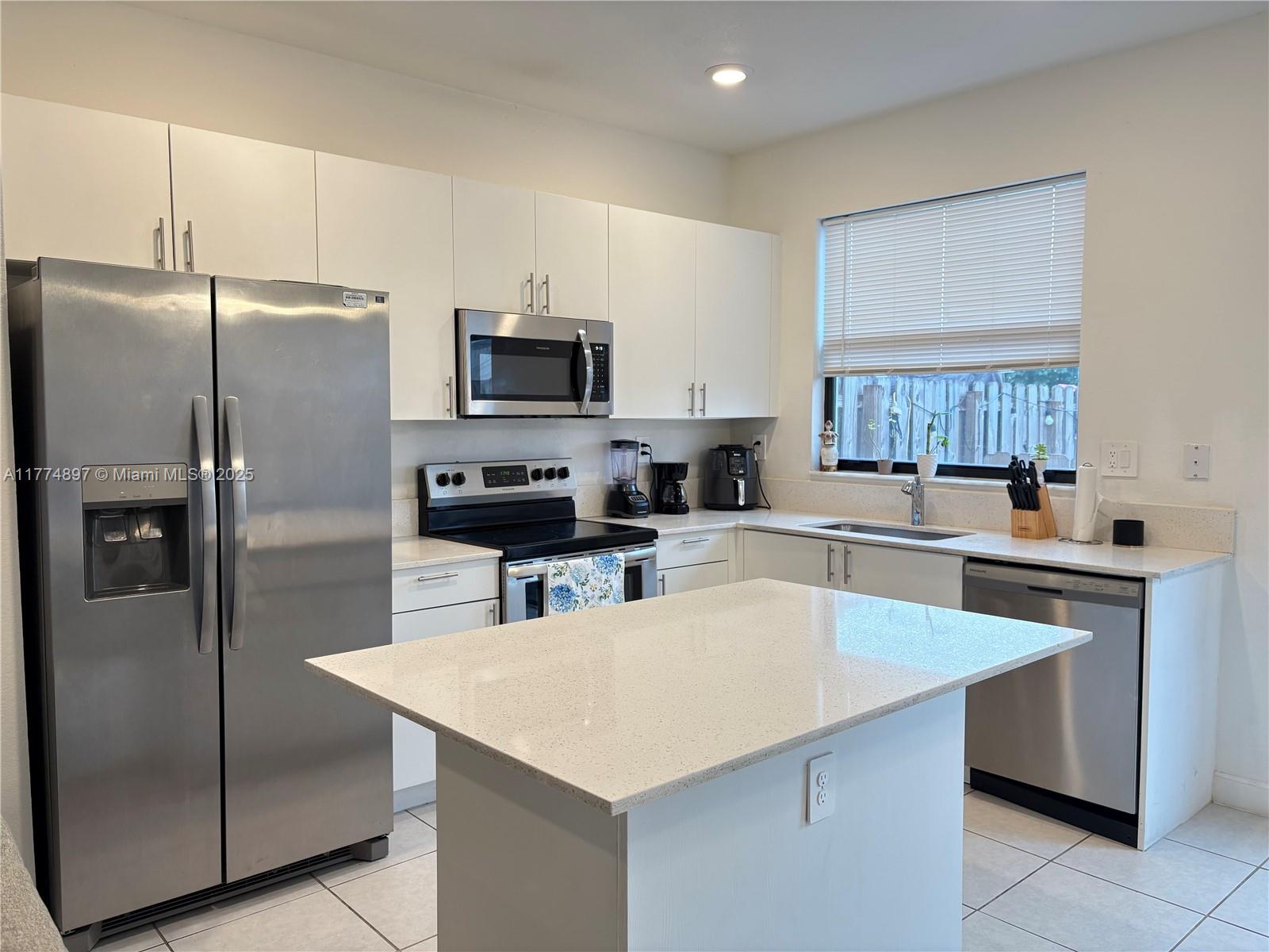 11772 Southwest 247th Terrace, Unit 11772 Homestead, FL 33032 - Photo 2 of 27 a kitchen with stainless steel appliances a refrigerator a stove a sink a center island and a refrigerator