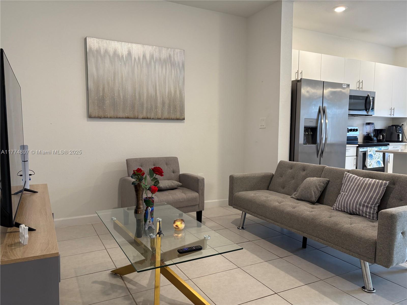 11772 Southwest 247th Terrace, Unit 11772 Homestead, FL 33032 - Photo 4 of 27 a living room with furniture and a flat screen tv