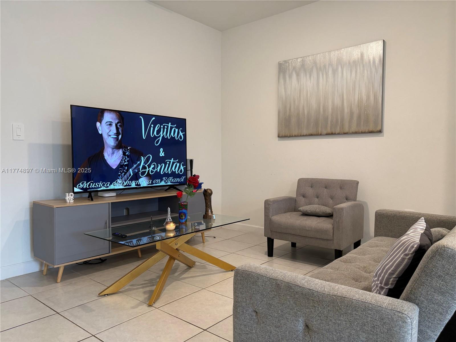 11772 Southwest 247th Terrace, Unit 11772 Homestead, FL 33032 - Photo 5 of 27 a living room with furniture and a flat screen tv