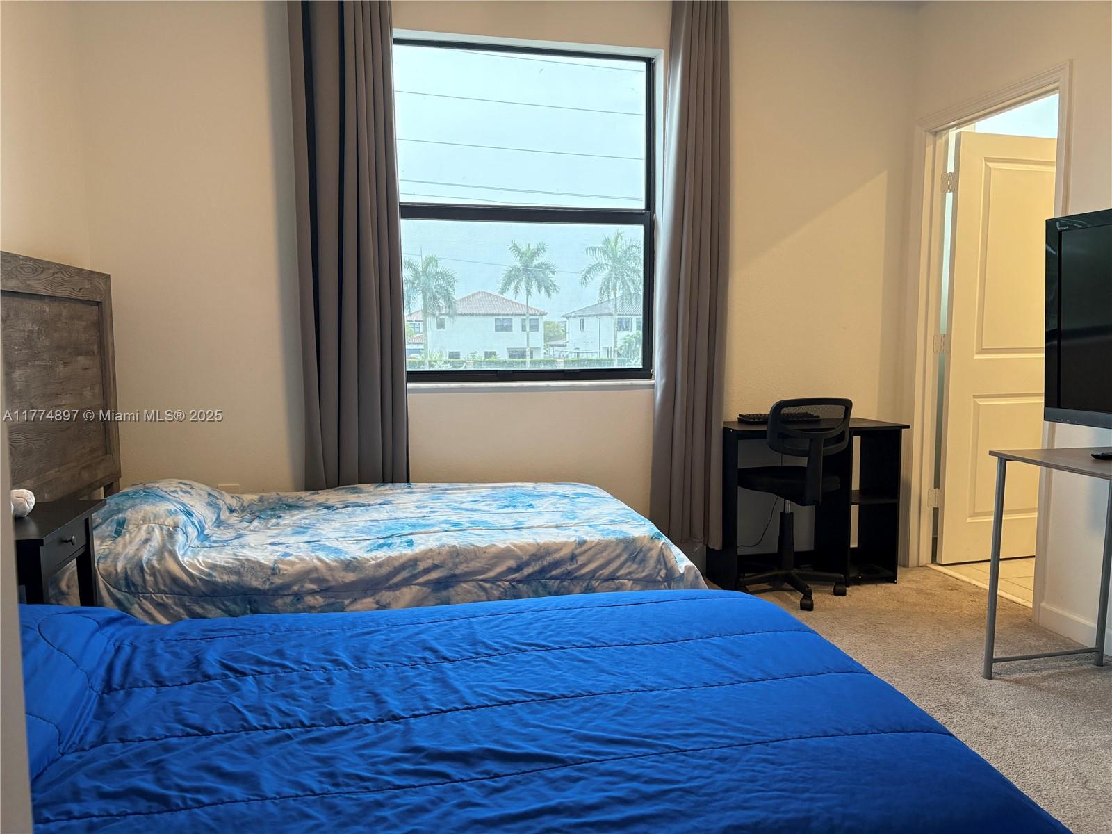 11772 Southwest 247th Terrace, Unit 11772 Homestead, FL 33032 - Photo 10 of 27 a bedroom with a bed and a television