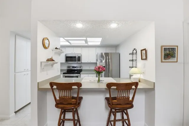 a kitchen with stainless steel appliances granite countertop a refrigerator and a stove top oven