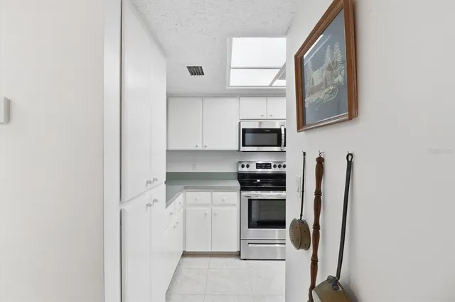 a kitchen with stainless steel appliances white cabinets and a refrigerator