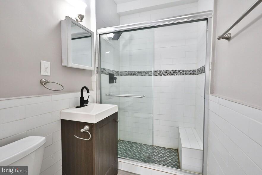 4247 Locust Street, Unit 1B703 Philadelphia, PA 19104 - Photo 26 of 38 a bathroom with a sink a toilet and shower