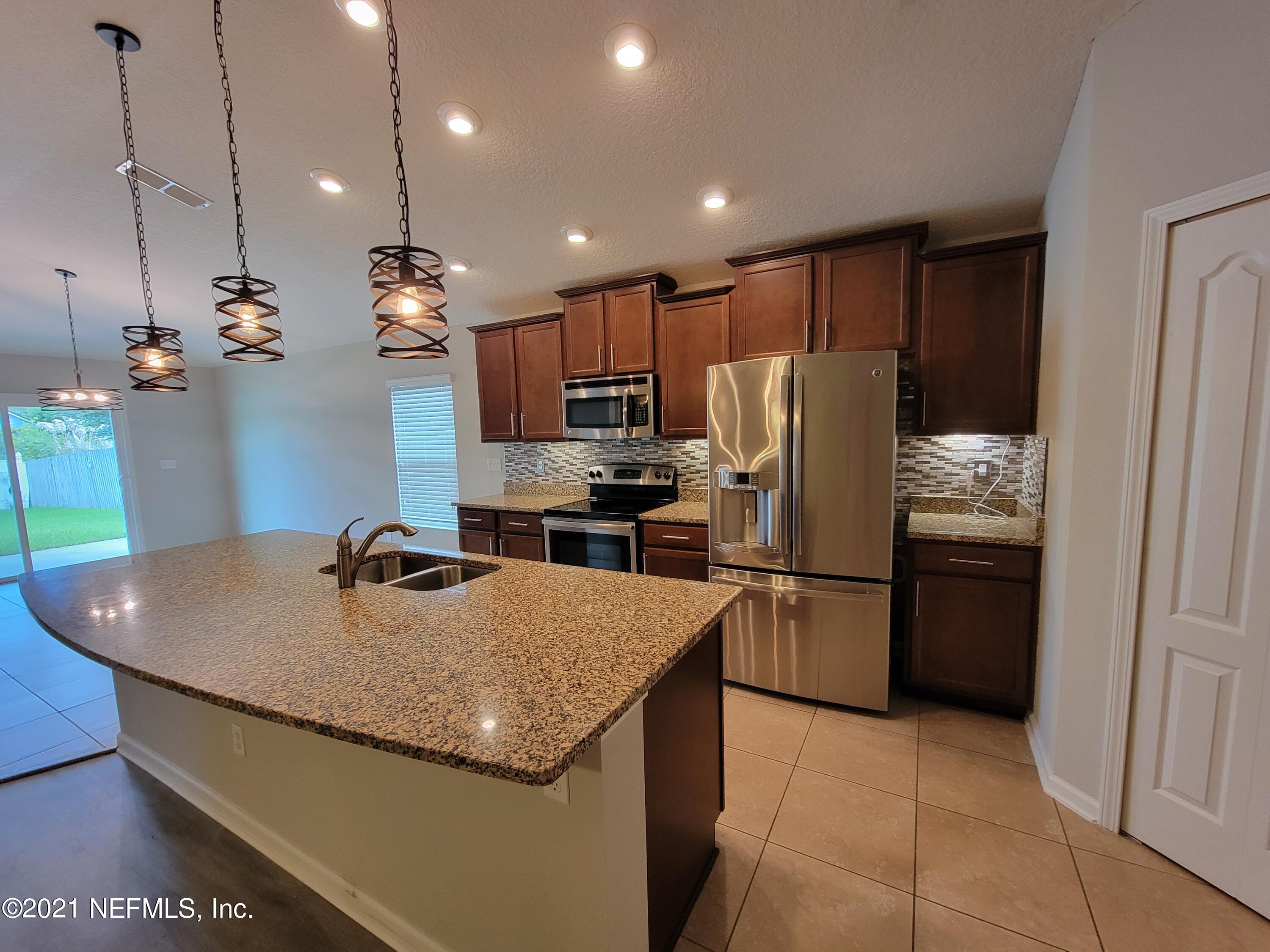 13471 Devan Lee Drive East Jacksonville, FL 32226 - Photo 4 of 10 a kitchen with refrigerator and stove