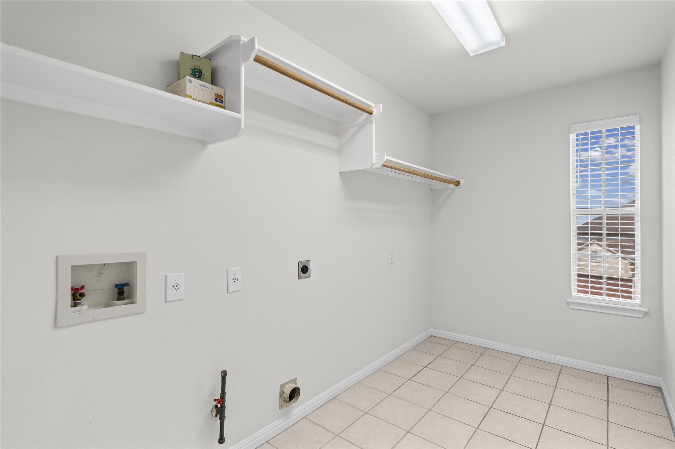 10700 Pointe View Drive Austin, TX 78738 - Photo 25 of 35 A dedicated utility space offers practical shelving and hanging rods for effortless laundry management.