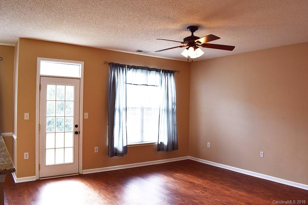 138 Bluffton Road Mooresville, NC 28115 - Photo 4 of 19 a view of an empty room with a window and wooden floor