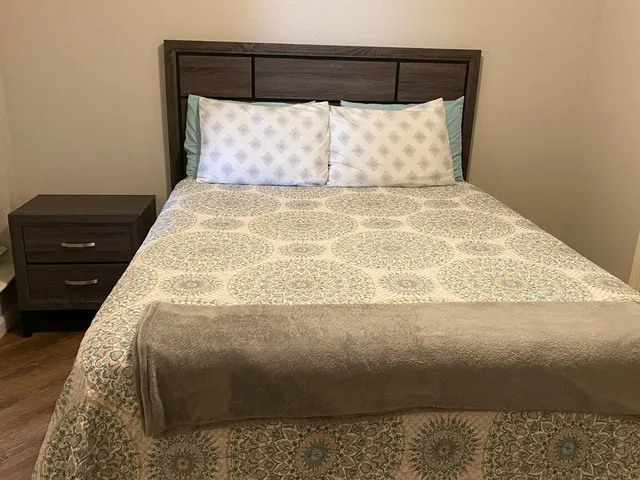 a bed sitting in a bedroom next to a lamp