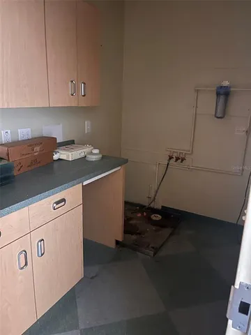 a kitchen with cabinets and a refrigerator