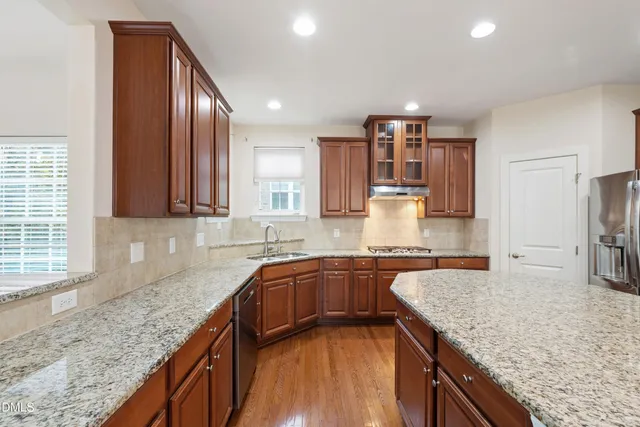 a kitchen with stainless steel appliances granite countertop a sink stove and refrigerator