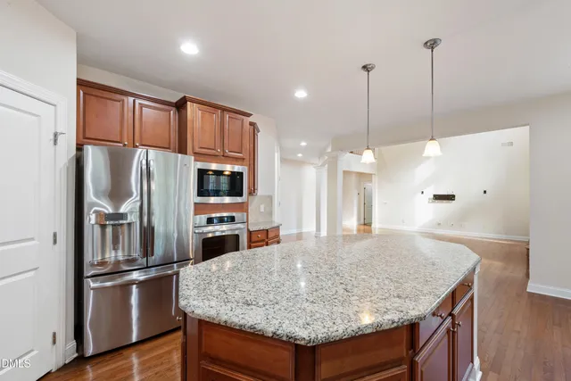 a kitchen with stainless steel appliances granite countertop a refrigerator a stove and a sink