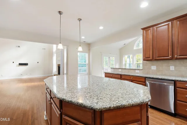a kitchen with stainless steel appliances granite countertop wooden cabinets a refrigerator and a sink