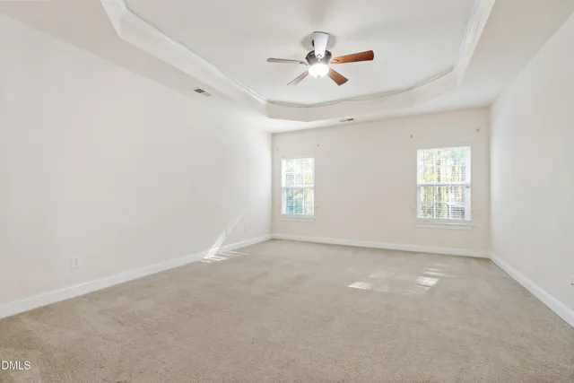 an empty room with windows and ceiling fan view