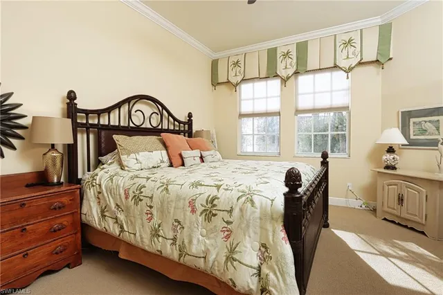 a bedroom with a bed a mirror on dresser and a window