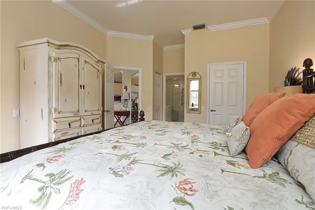 a spacious bedroom with a bed and a mirror