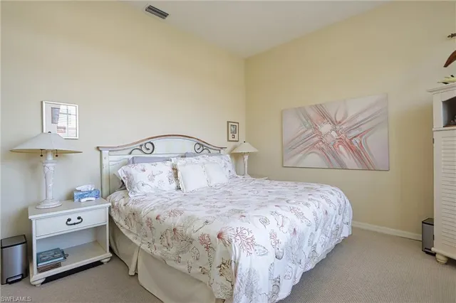 a bedroom with a bed and painting on the wall