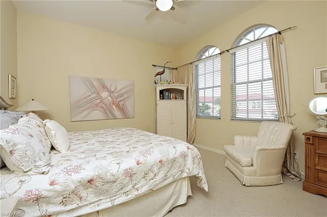 a bedroom with a bed a couch and a chandelier