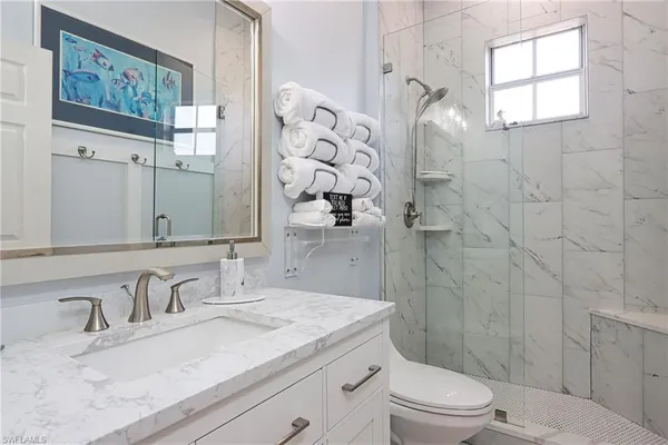 a bathroom with a granite countertop sink toilet and shower