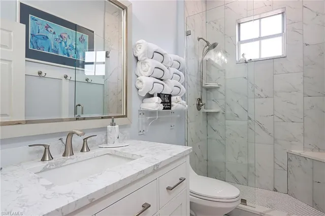 a bathroom with a granite countertop sink toilet and shower