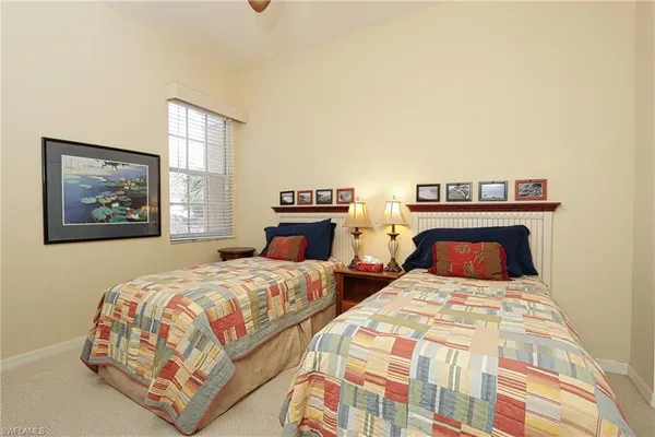 a bedroom with two beds and a painting on the wall