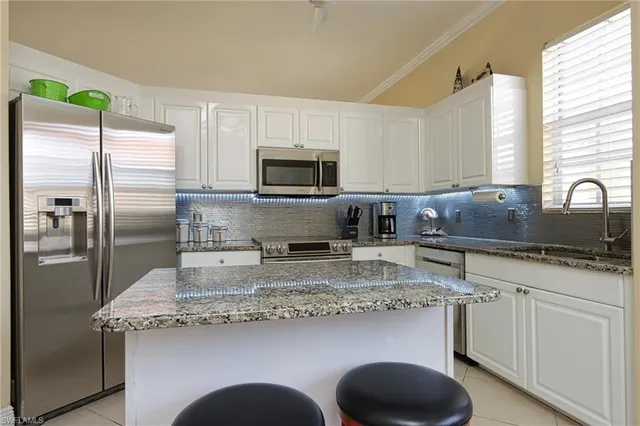 a kitchen with kitchen island granite countertop a sink stainless steel appliances and counter space