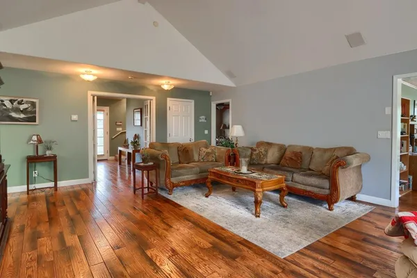 a living room with furniture and a wooden floor