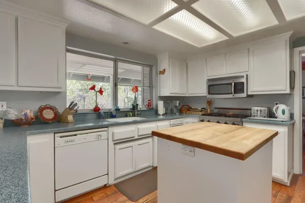 a kitchen with a sink a counter top space cabinets and stainless steel appliances