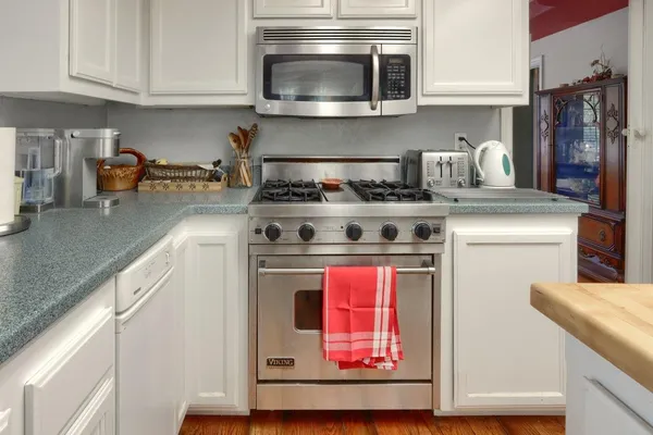 a kitchen with stainless steel appliances granite countertop a stove and a microwave