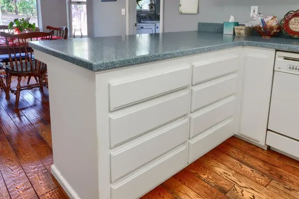 a kitchen with cabinets and wooden floor