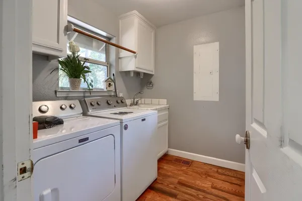 a utility room with cabinets washer and dryer