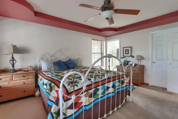 a bedroom with a bed next to a window and a chandelier