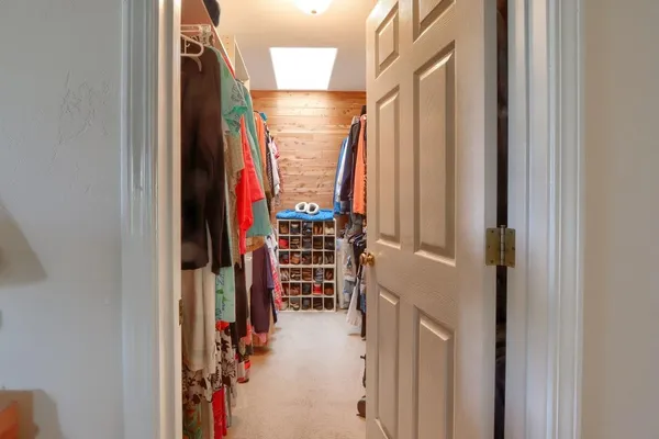 a view of walk in closet with clothes