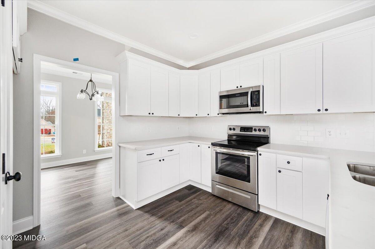 255 High Ridge Court Macon, GA 31220 - Photo 10 of 28 a kitchen with granite countertop a refrigerator stove and white cabinets