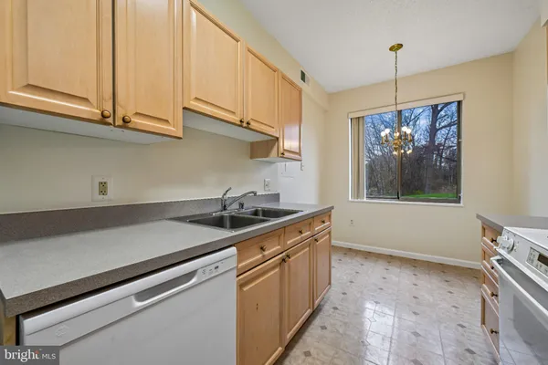 a kitchen with stainless steel appliances granite countertop a sink a stove and a wooden cabinets