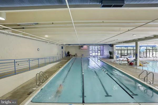 a kitchen with stainless steel appliances granite countertop a refrigerator a sink dishwasher and wooden cabinets with wooden floor