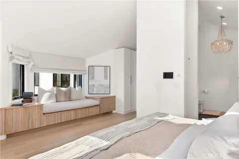 a bedroom with a bed and a lamp on dresser