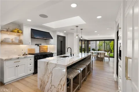 a large kitchen with stainless steel appliances kitchen island granite countertop a large counter top and a stove top oven