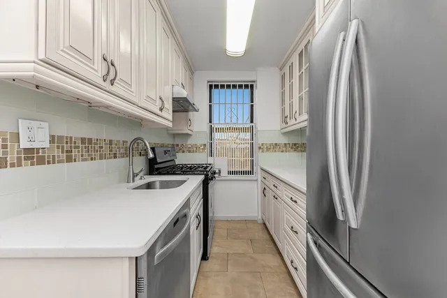 a kitchen with stainless steel appliances granite countertop a refrigerator and a stove