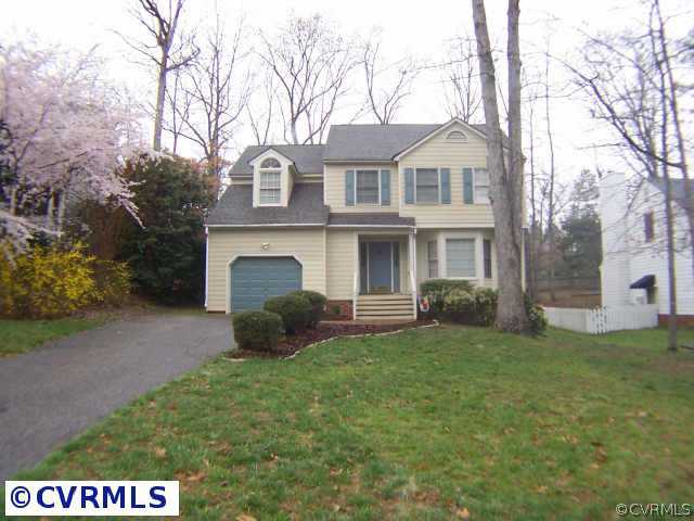 a front view of a house with a garden and yard